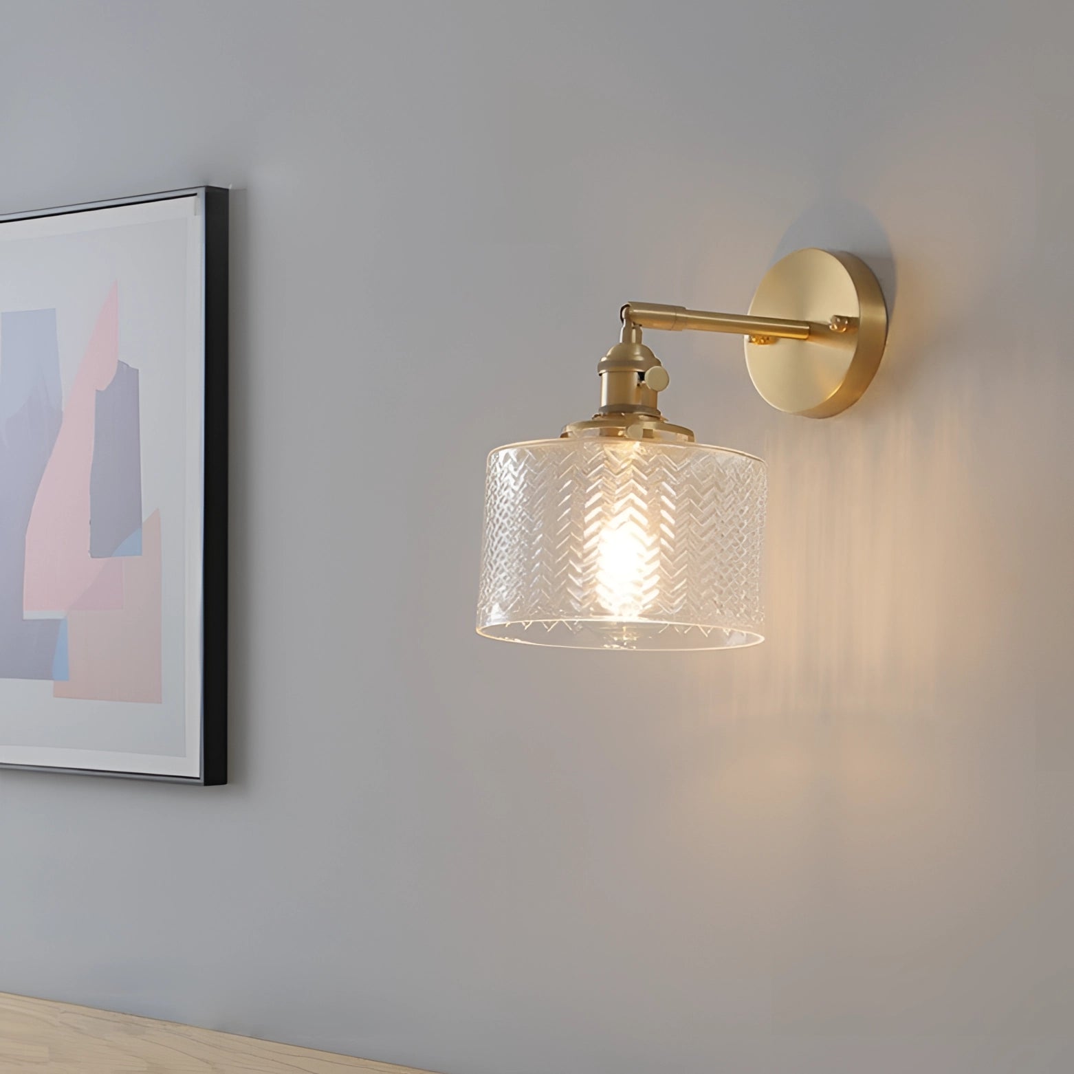 A brass wall lamp with a green chevron geometric pattern, featuring a rectangular wooden base and metal sconce design.