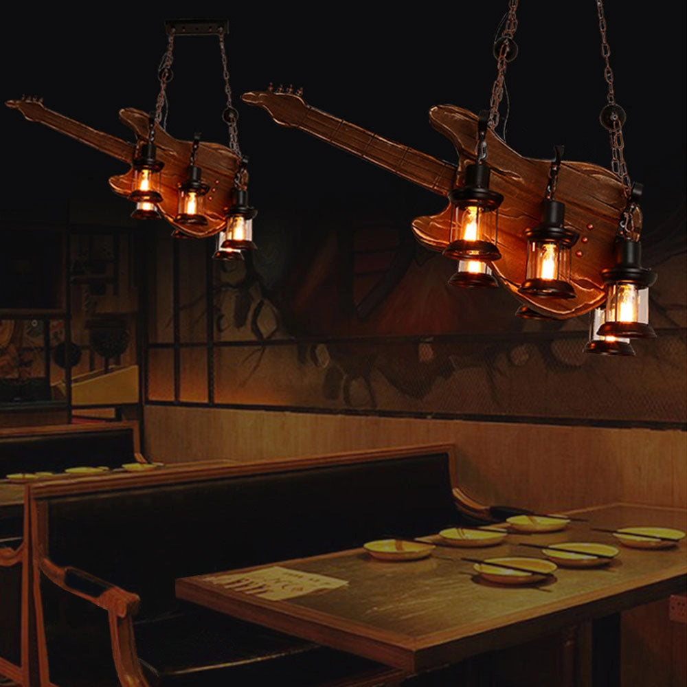 Vintage guitar-shaped pendant light fixture with a metal and wood design, hanging in a dimly lit space, casting warm, ambient lighting.