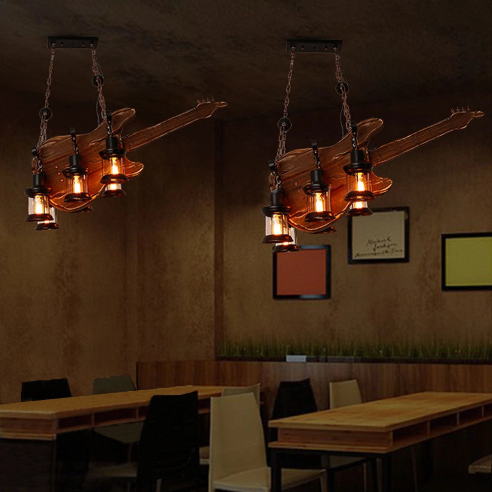 Guitar-shaped pendant light chandelier with a vintage music theme, featuring amber and orange hues, hanging from a ceiling in a stylish interior design setting.