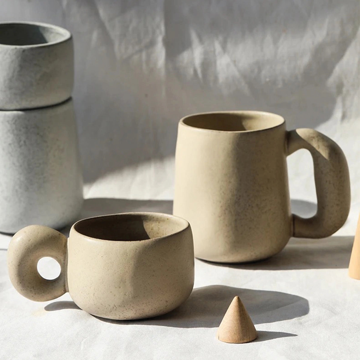 Handcrafted speckled ceramic mug in beige color, large size, eco-friendly artisan coffee cup placed on a table.