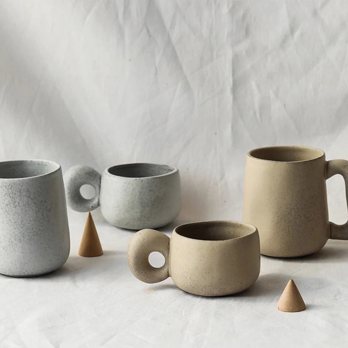 Handcrafted speckled ceramic mug positioned on a table, showcasing its eco-friendly design and artisan craftsmanship, suitable for coffee or tea.