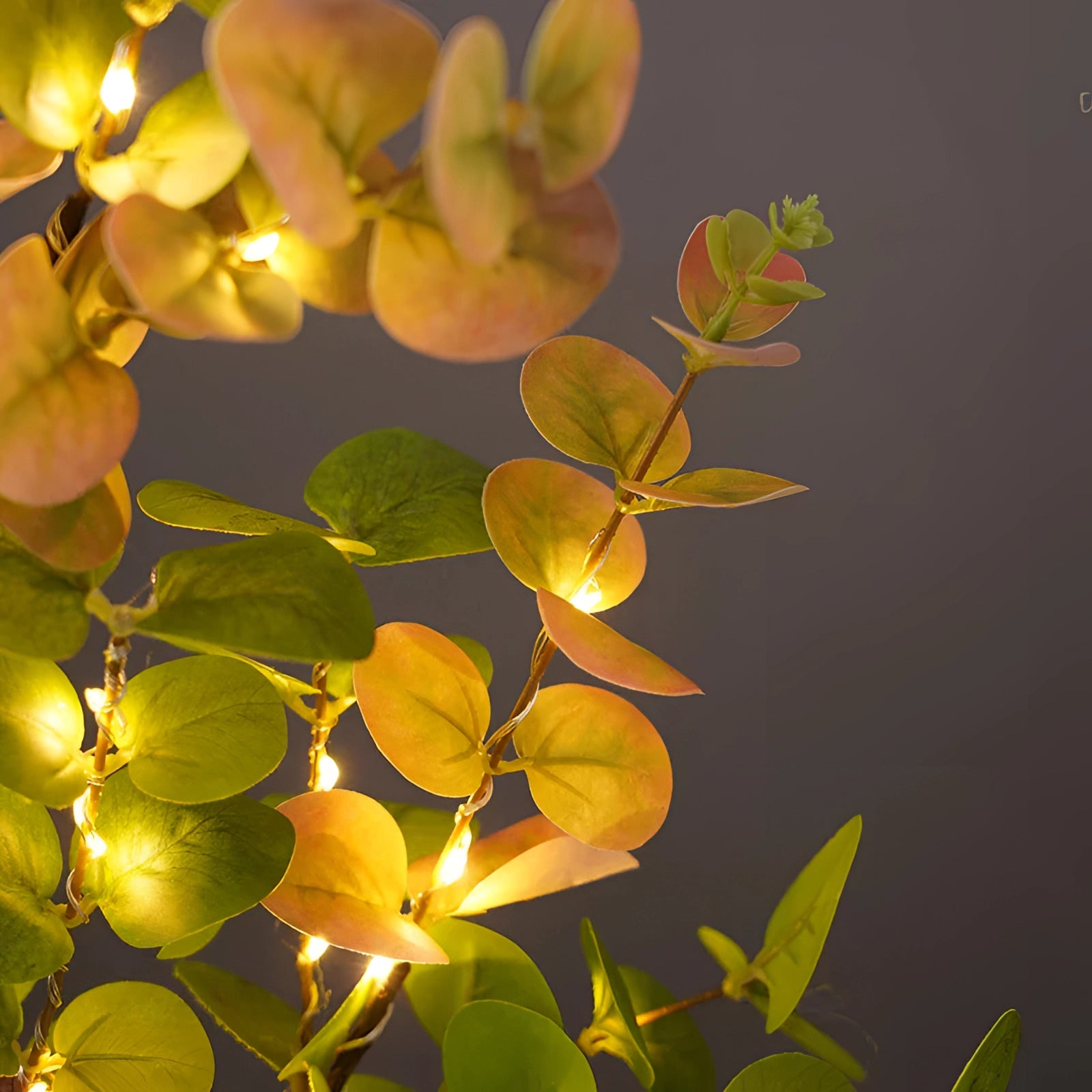 Indoor decorative olive tree lamp with LED lights featuring realistic branches and twigs, adorned with warm amber LED lights mimicking petals, creating a soft, ambient glow.