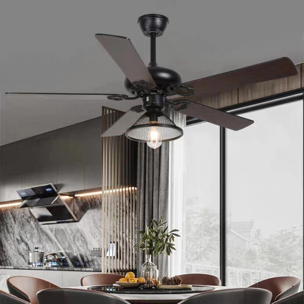 Industrial black ceiling fan with light and remote, featuring a vintage design suitable for outdoor use, installed above a wooden table, surrounded by houseplants and flowerpots in a stylish interior setting.