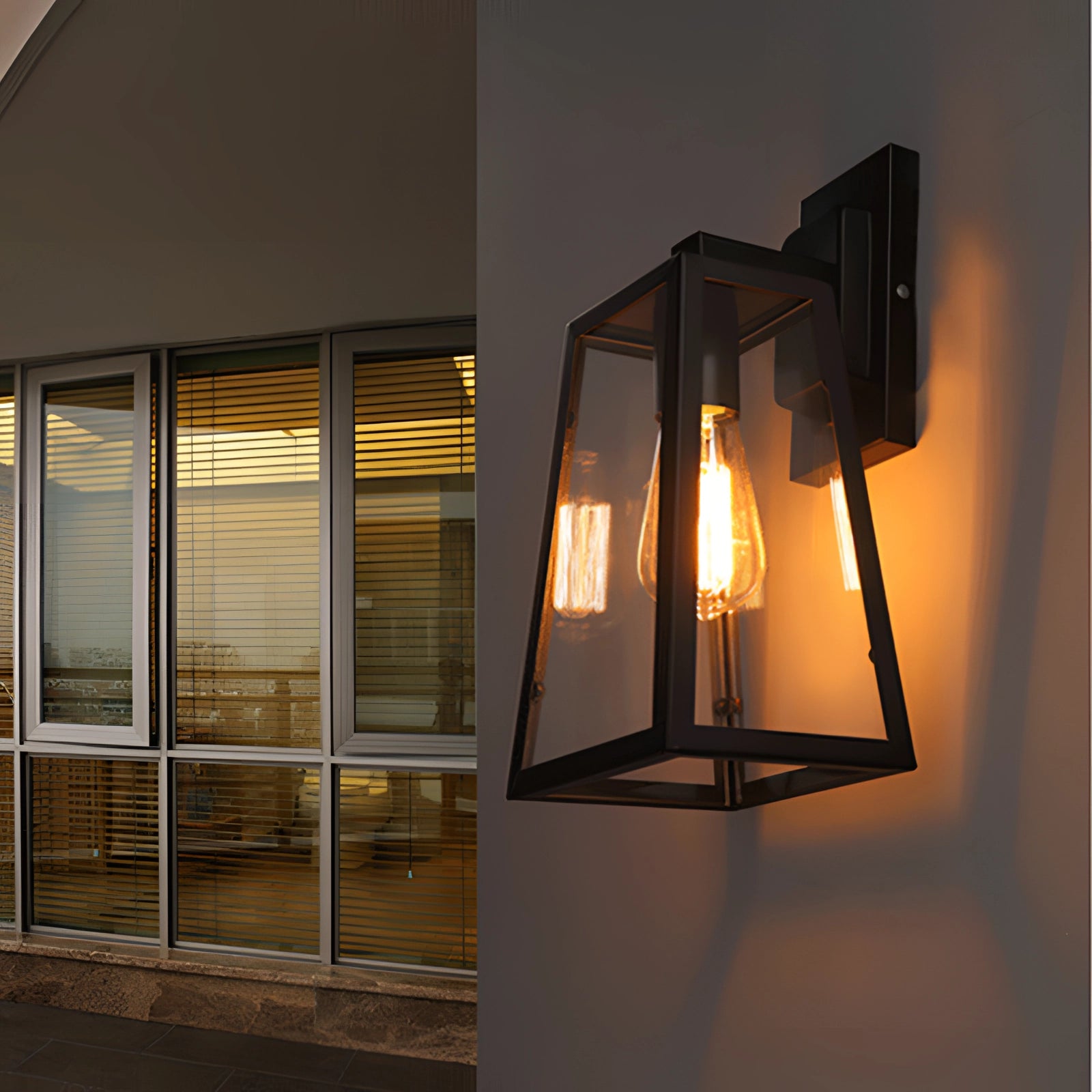 Industrial black trapezoidal wall sconce with a modern twin bulb design, featuring amber-tinted glass shades, suitable for interior design.