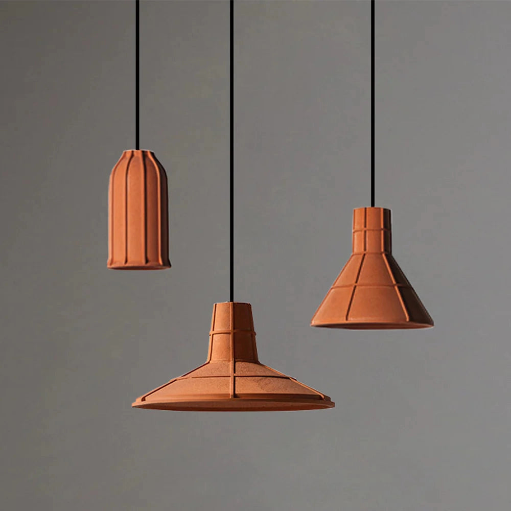 Industrial gray concrete pendant light with a minimalist design, featuring a cylindrical lampshade and metal accents, suspended from the ceiling.