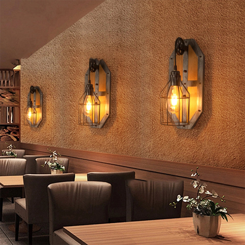 Industrial vintage pulley wall lamp with rustic wood and metal design mounted on a wall, illuminating the interior space, surrounded by furniture and decor elements like a table, chair, and plant.