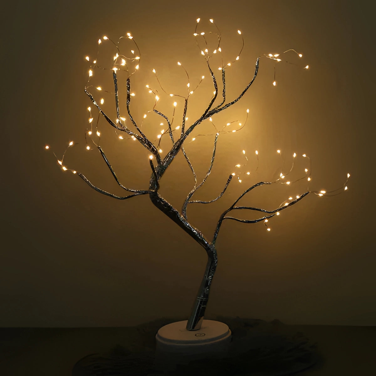 LED Bonsai Tree Light with warm white LEDs resembling a small illuminated tree with twig-like branches, set in a dark environment to highlight its artistic and ambient glow.