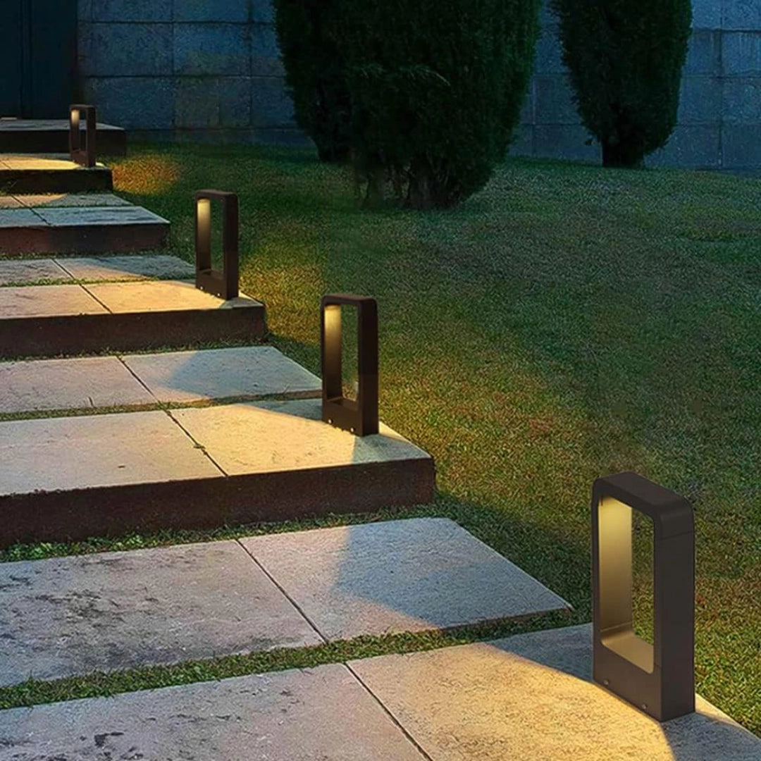 LED garden pathway lights illuminating a landscaped outdoor area with a paved pathway surrounded by grass, showcasing energy-efficient and weather-resistant design.