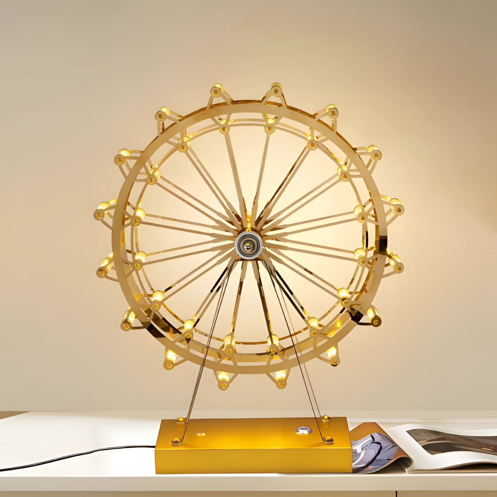 LED Gold Ferris Wheel Table Lamp featuring a modern design with a circular, symmetrical gold structure resembling a Ferris wheel, emitting a warm amber glow, suitable for decorative purposes on tables.
