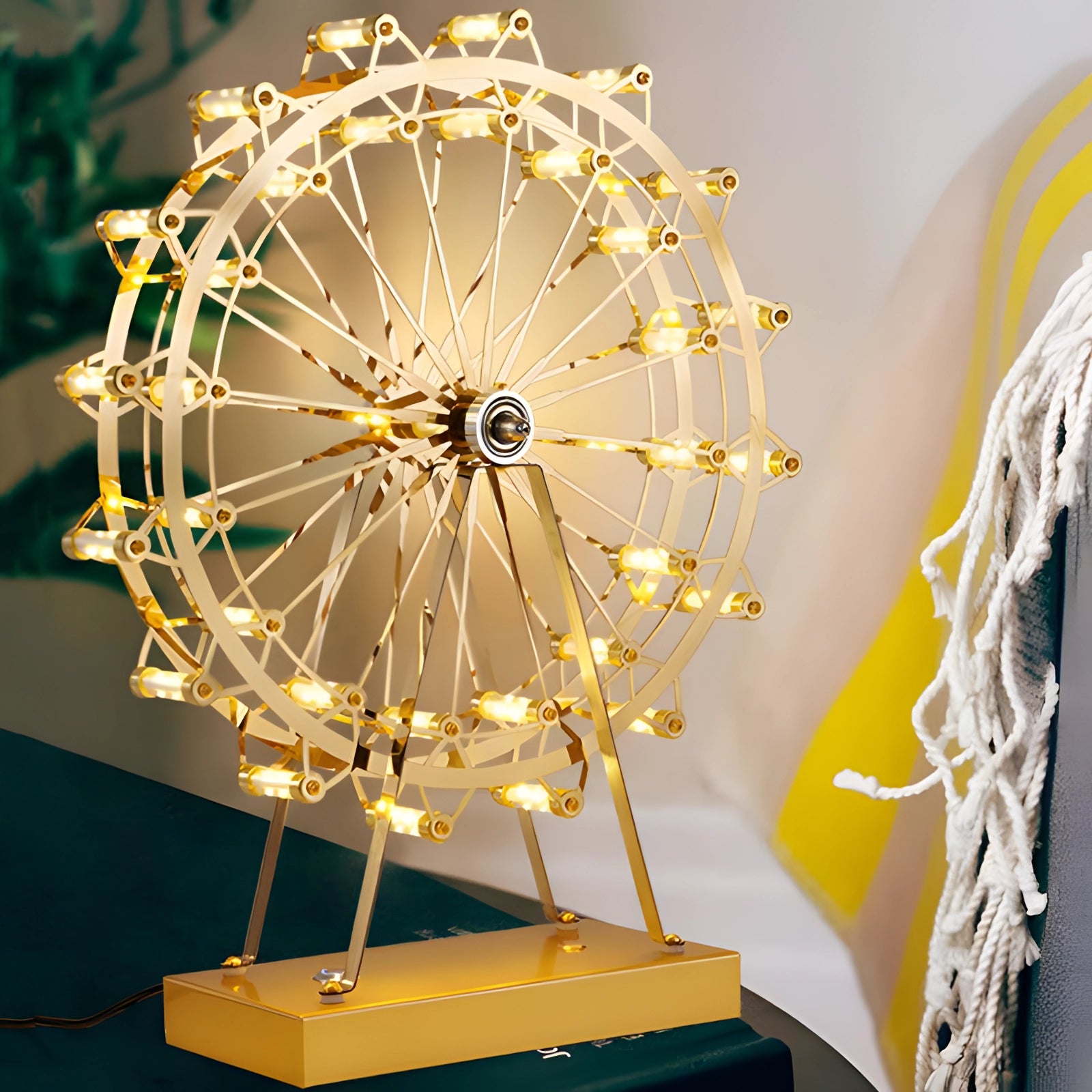 LED Gold Ferris Wheel Table Lamp with a modern design featuring a circular metal structure in a warm amber and yellow hue, creating symmetrical patterns that resemble a decorative fashion accessory.