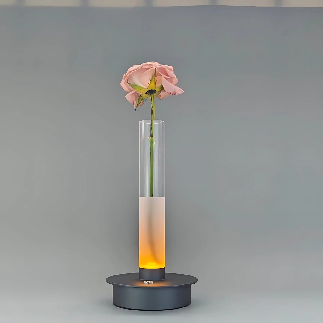 LED illuminated minimalist vase in gray, featuring a modern frosted glass design, elegantly holding a bouquet of artificial flowers with vibrant petals.