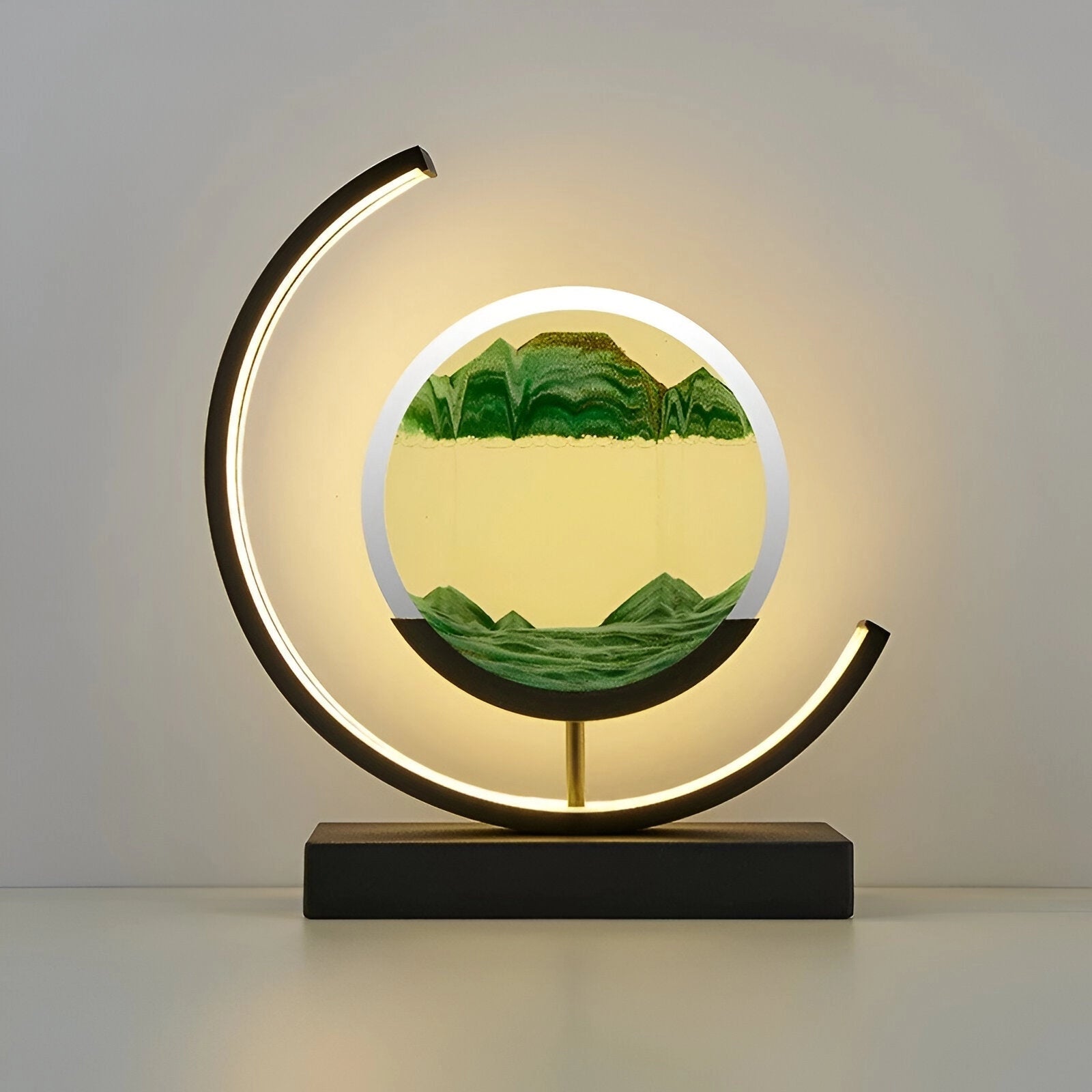 LED Kinetic Sand Lamp in Crescent Moon Design with Green Mood Lighting featuring a sleek rectangular base and circular crescent moon emblem, set against a backdrop that highlights its artistic and modern appearance.