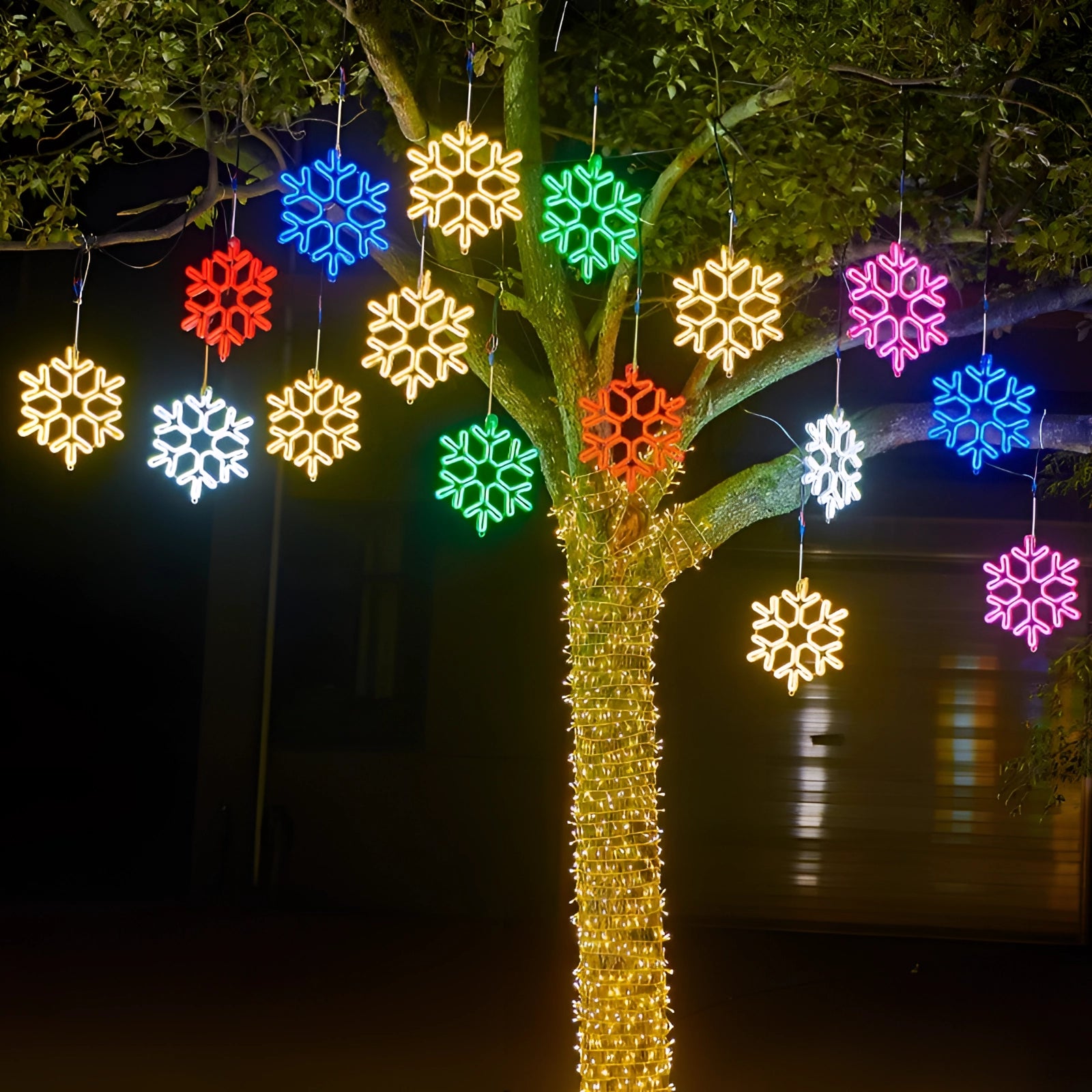 LED snowflake light mounted on a tree branch at night, illuminating the outdoor space as a waterproof Christmas decoration.