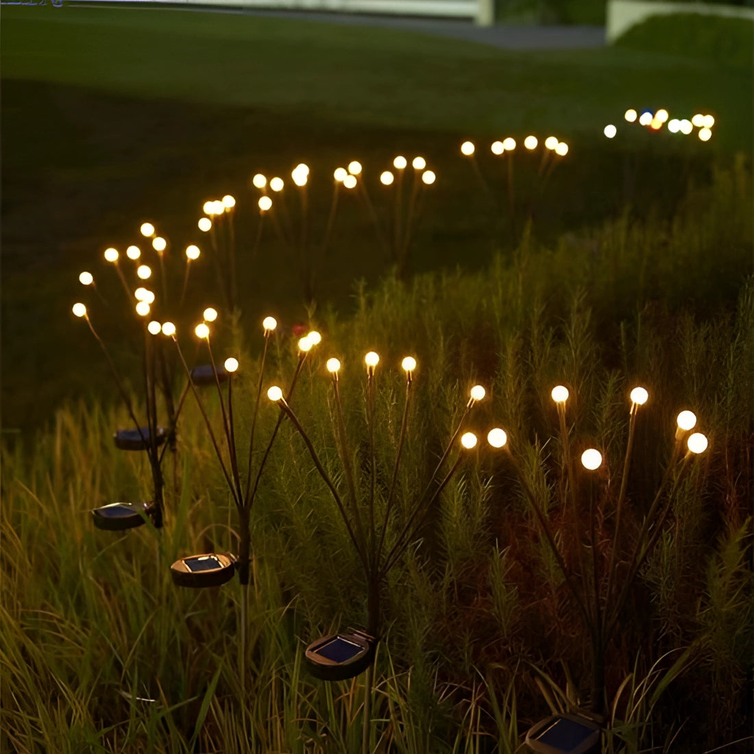 LED solar stake lights illuminating a garden at night, surrounded by grass and plants, creating a decorative and energy-efficient landscape.
