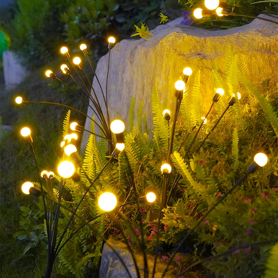 LED solar stake lights illuminating a garden area, featuring 40 decorative and waterproof pieces mimicking natural elements like branches and leaves, creating an energy-efficient and festive ambiance.