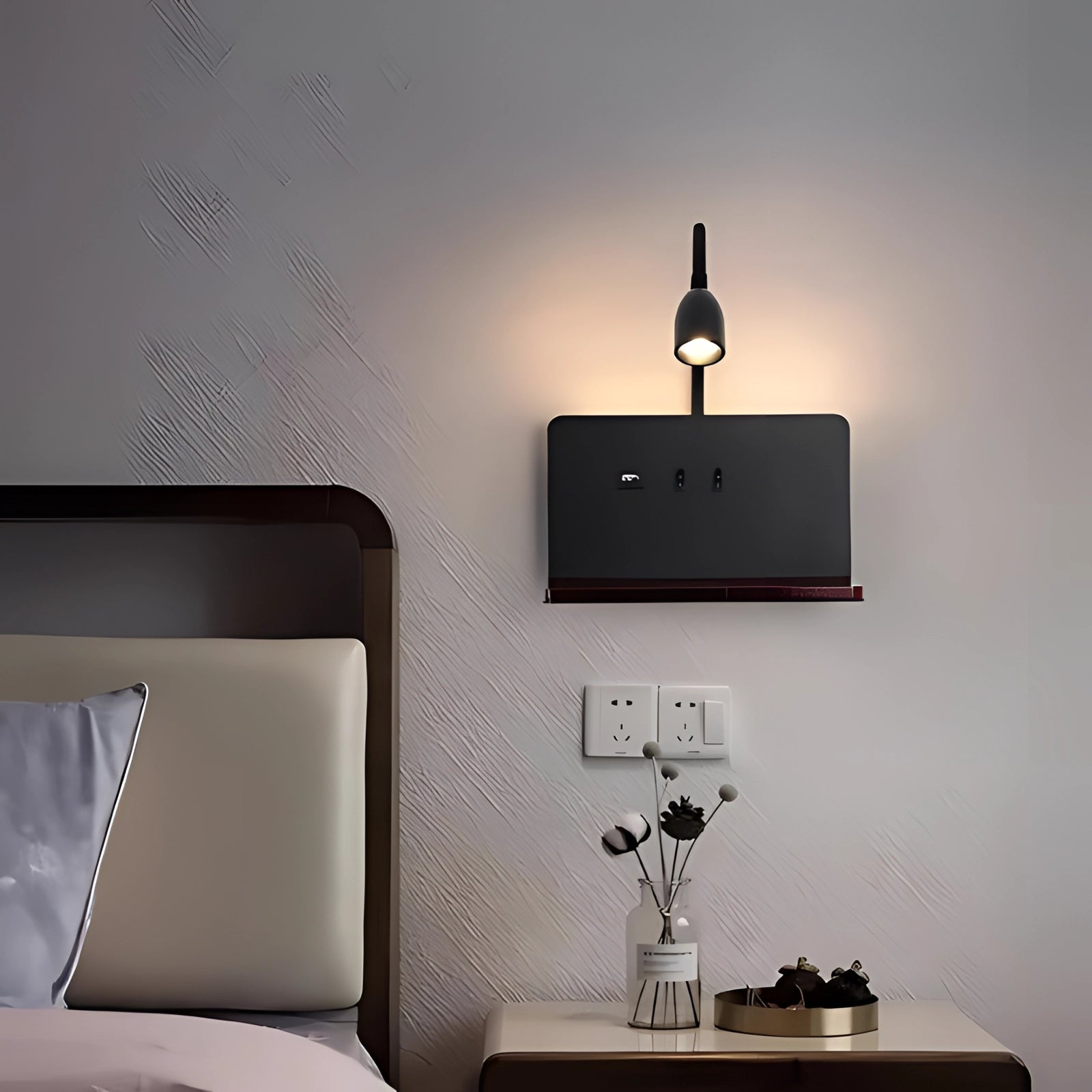 LED wall lamp with USB charging mounted on a wall, featuring a flexible gooseneck design and a rectangular wooden shelf. The lamp is surrounded by a stylish interior setting with a hint of greenery, complementing the modern decor.
