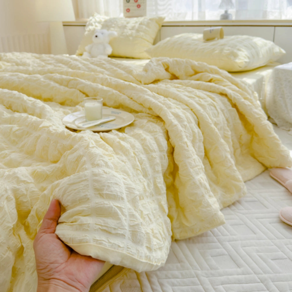 Light blue ruffled comforter set with a plush textured design, displayed on a bed, accompanied by two matching pillowcases. The bedding is styled in a 200x230cm size, featuring a luxurious and cozy appearance.