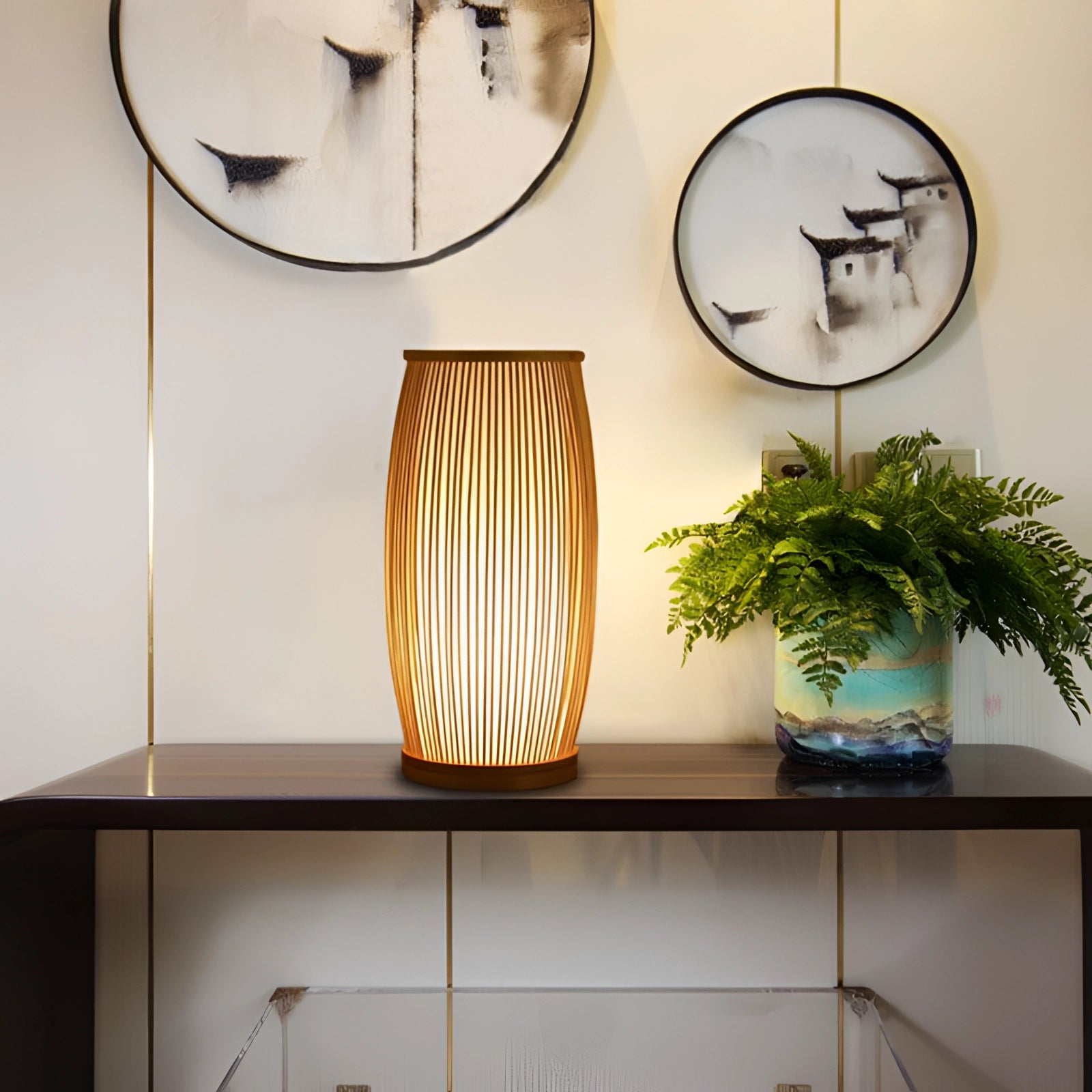 A modern luxury bamboo bedside lamp emitting a warm white light, placed on a wooden table with minimalist interior design elements and decorative plants in the background.