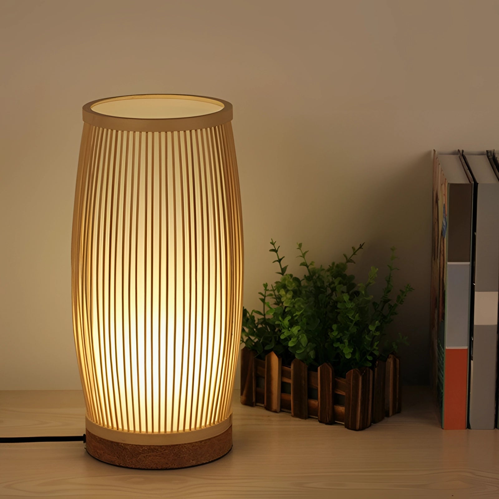 Luxury bamboo bedside lamp with a modern design, featuring a cylindrical shape crafted from natural wood material. The lamp is placed on a wooden surface, surrounded by houseplants, creating a stylish and artistic ambiance in the bedroom.