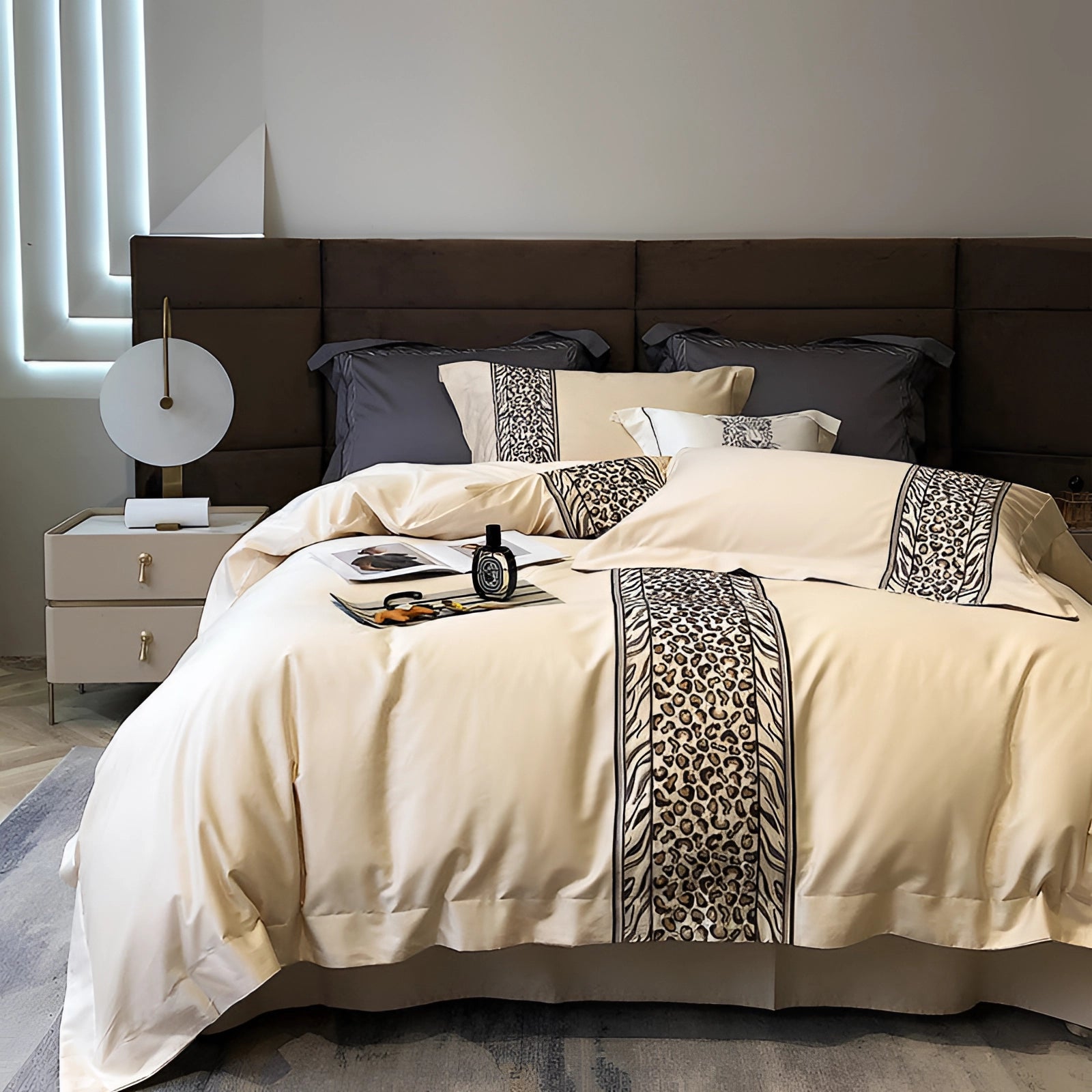 King-sized luxury bedding set featuring an elegant gray and white comforter with a cream duvet cover, displayed on a wooden bed frame with matching pillows, in a cozy and comfortable bedroom setting.