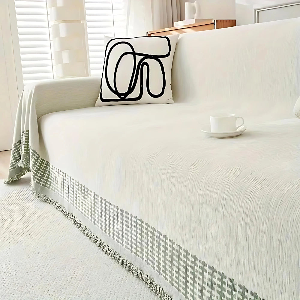 Luxury beige couch cover featuring a classic houndstooth pattern, draped elegantly over a sofa in a stylishly designed interior setting with wooden flooring and complementary decor elements.