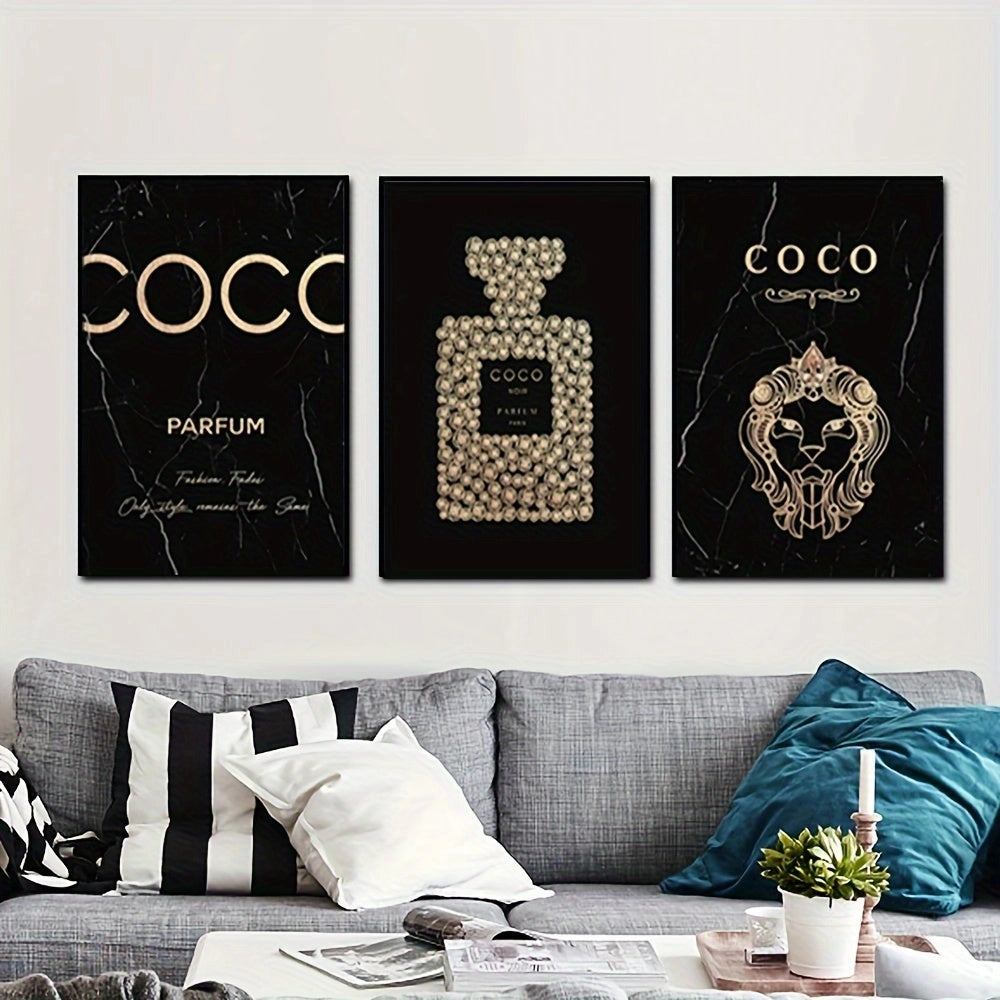 Luxury black and gold perfume-themed canvas trio displayed on a wall in an elegantly designed living room, featuring a couch adorned with grey and white pillows, a small side table, and a lush green plant.