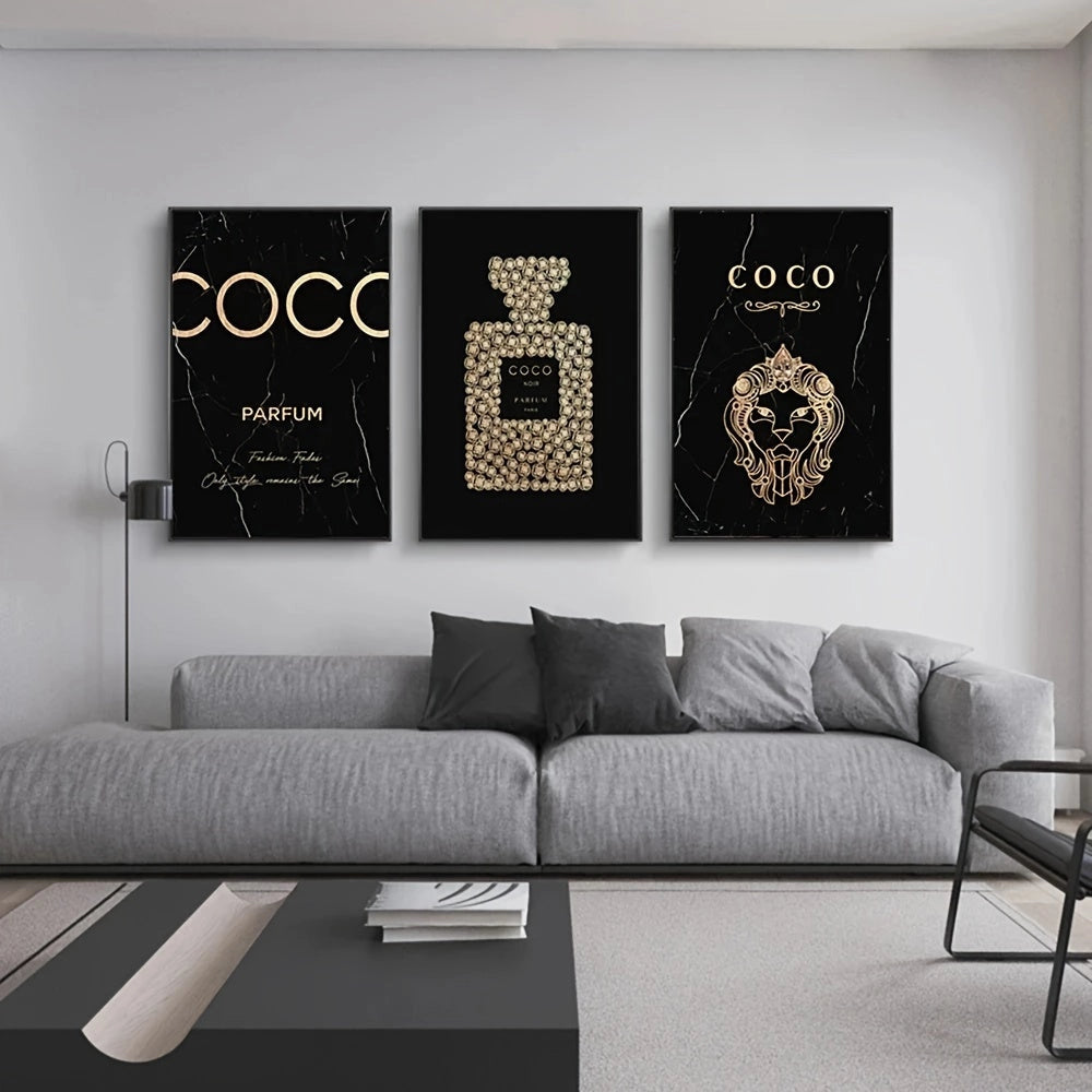 Luxurious black and gold perfume-themed triptych canvas art displayed above a modern grey couch in an elegantly designed living room with wooden flooring.