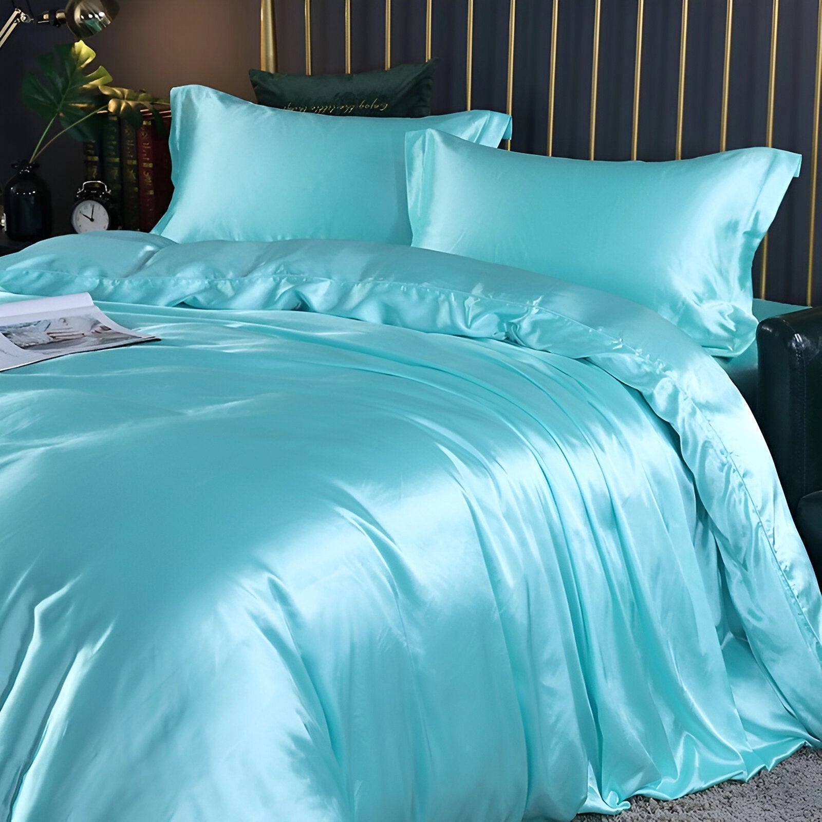 Luxury black leather bed with gold accents, styled with light blue bedding, including a 220x240 cm duvet and two pillowcases, set in a room with wooden flooring and featuring comfortable textiles.