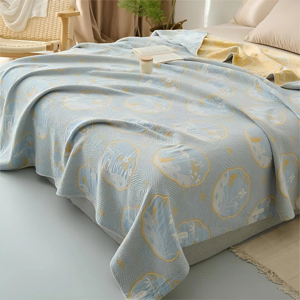 Luxury blue bedding set adorned with an ornate gold floral pattern, showcasing a sophisticated design in a stylish bedroom interior.