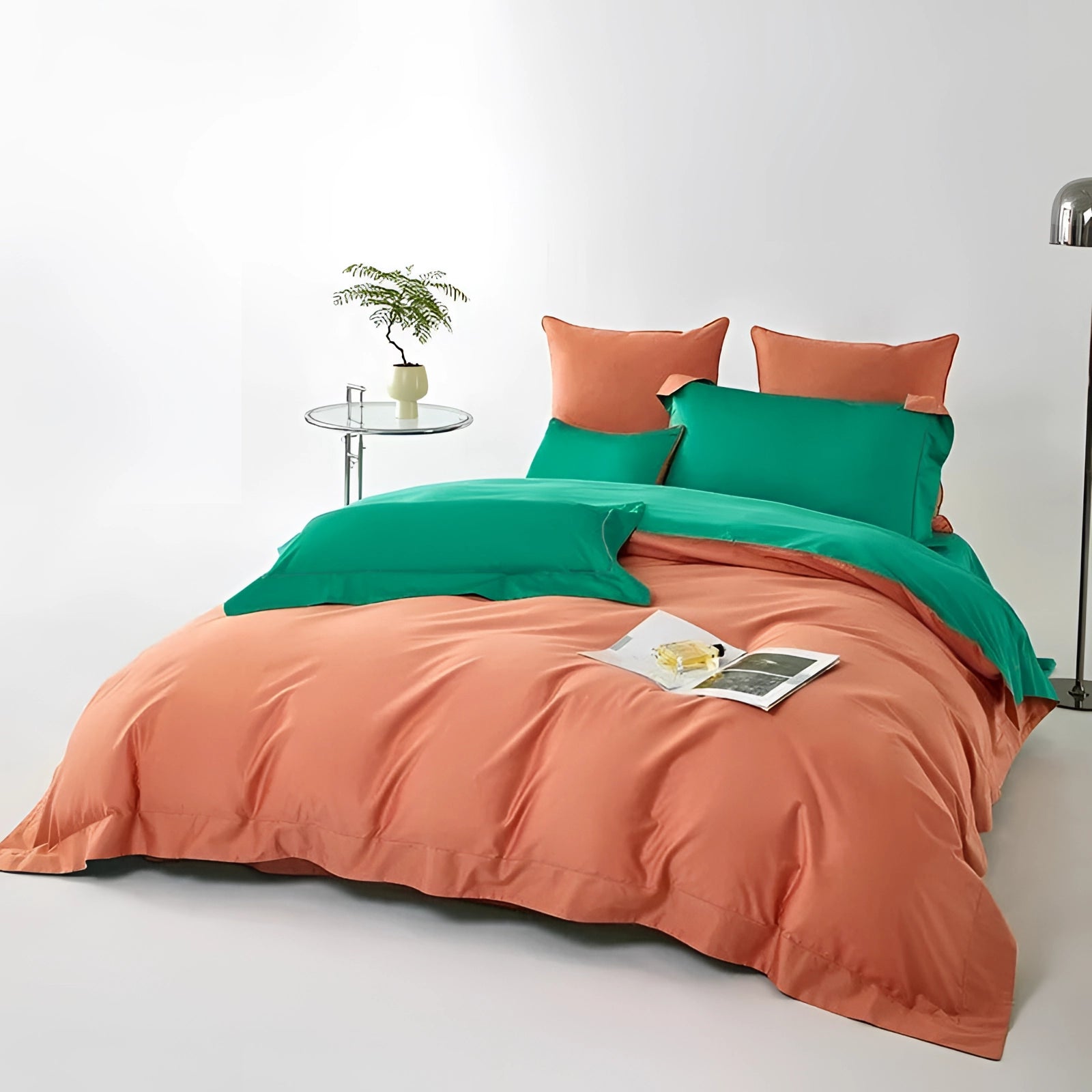 Luxurious coral and teal satin bedding set on an American king-size bed, featuring elegant queen duvet cover with plush pillows, set in a well-furnished bedroom with wooden bed frame and stylish interior accents.
