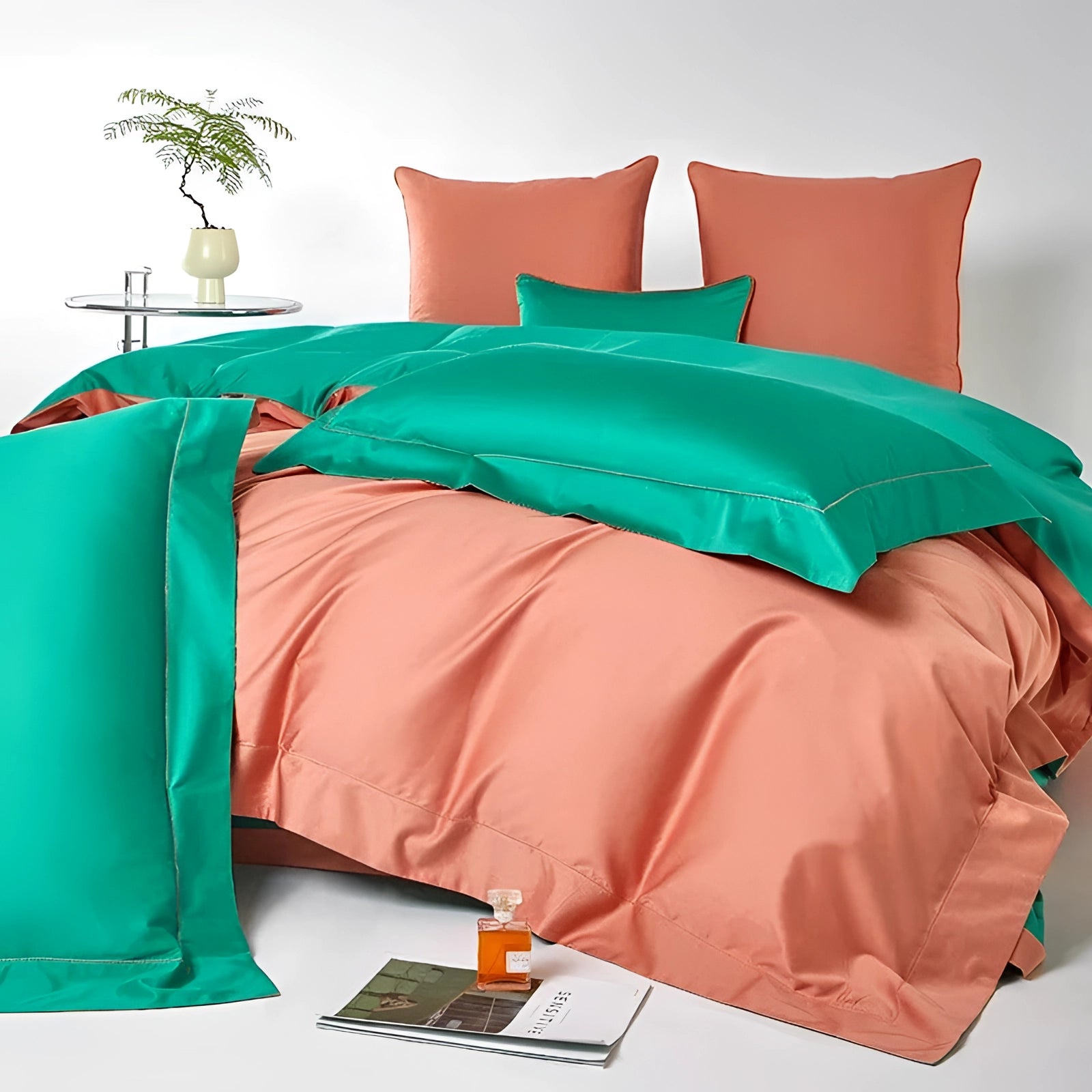 Luxurious satin bedding set featuring a coral and teal color scheme, elegantly displayed on a queen-sized bed. The duvet cover showcases a blend of green and azure tones, adding a touch of aqua elegance to the bedroom decor. Comfort and style are emphasized with high-quality textiles, complemented by a nearby houseplant.