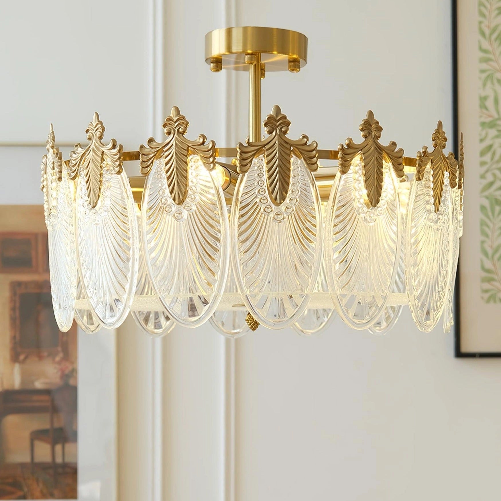 Luxurious gold leaf vintage crystal chandelier hanging from the ceiling, illuminating a room with wooden elements, curtains, and windows in the background.