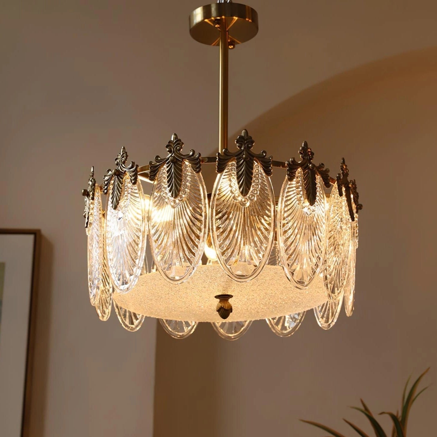 Luxurious vintage crystal chandelier with gold leaf finish hanging from ceiling, radiating light with intricate metalwork and elegant design.