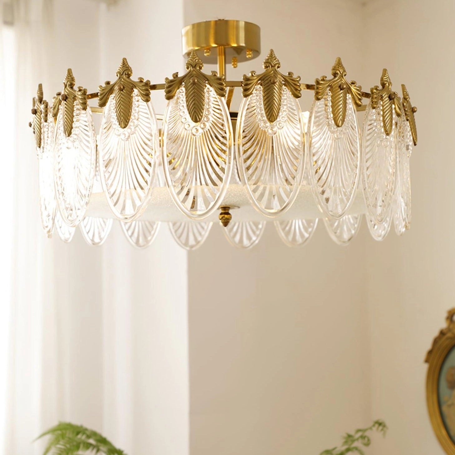 A luxurious crystal chandelier with gold leaf details, featuring vintage design, elegantly hung from the ceiling in a well-decorated interior space.
