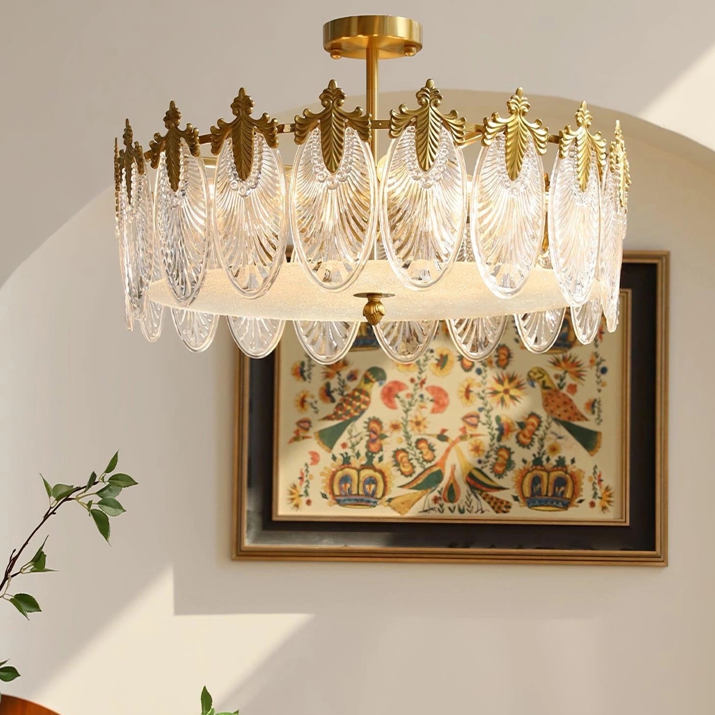 A luxurious gold leaf vintage crystal chandelier hanging from a ceiling, illuminating an elegantly designed interior space with ornamental details.