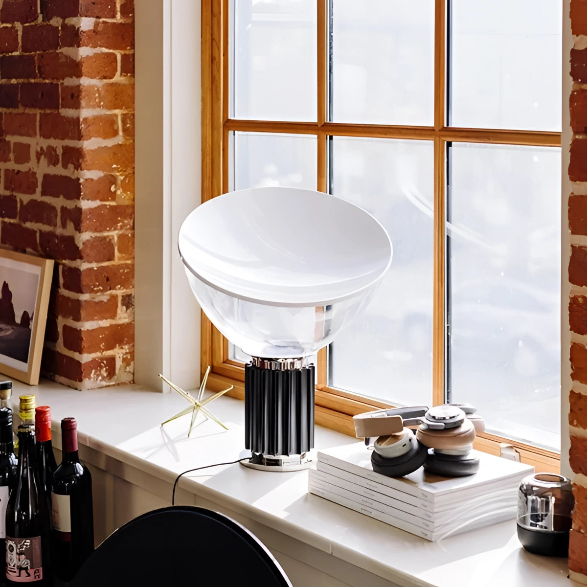 Luxurious designer glass lamp with a modern ribbed base and dome shade, placed on a hardwood surface in a stylish interior setting.