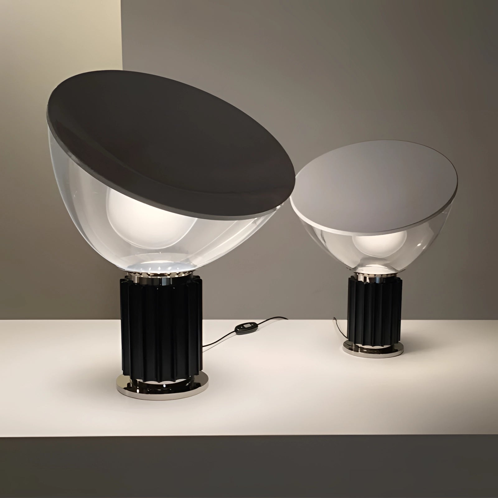 A luxury designer glass lamp with a modern ribbed base and dome-shaped shade, elegantly displayed on a table.
