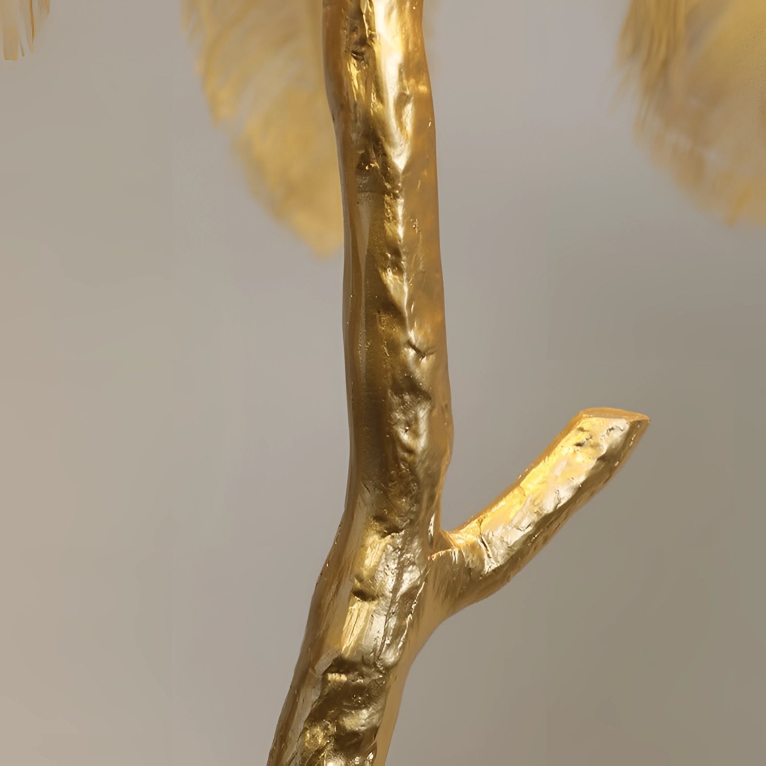 A gold palm tree art deco floor lamp with luxurious feather details and a sturdy metal base.