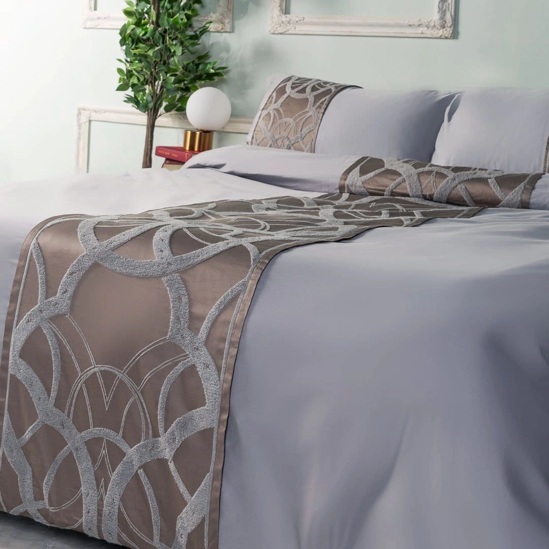 Luxurious taupe gray geometric satin bedding set displayed in a stylish bedroom with matching pillows, wooden furniture, and a comfortable interior featuring a touch of greenery.