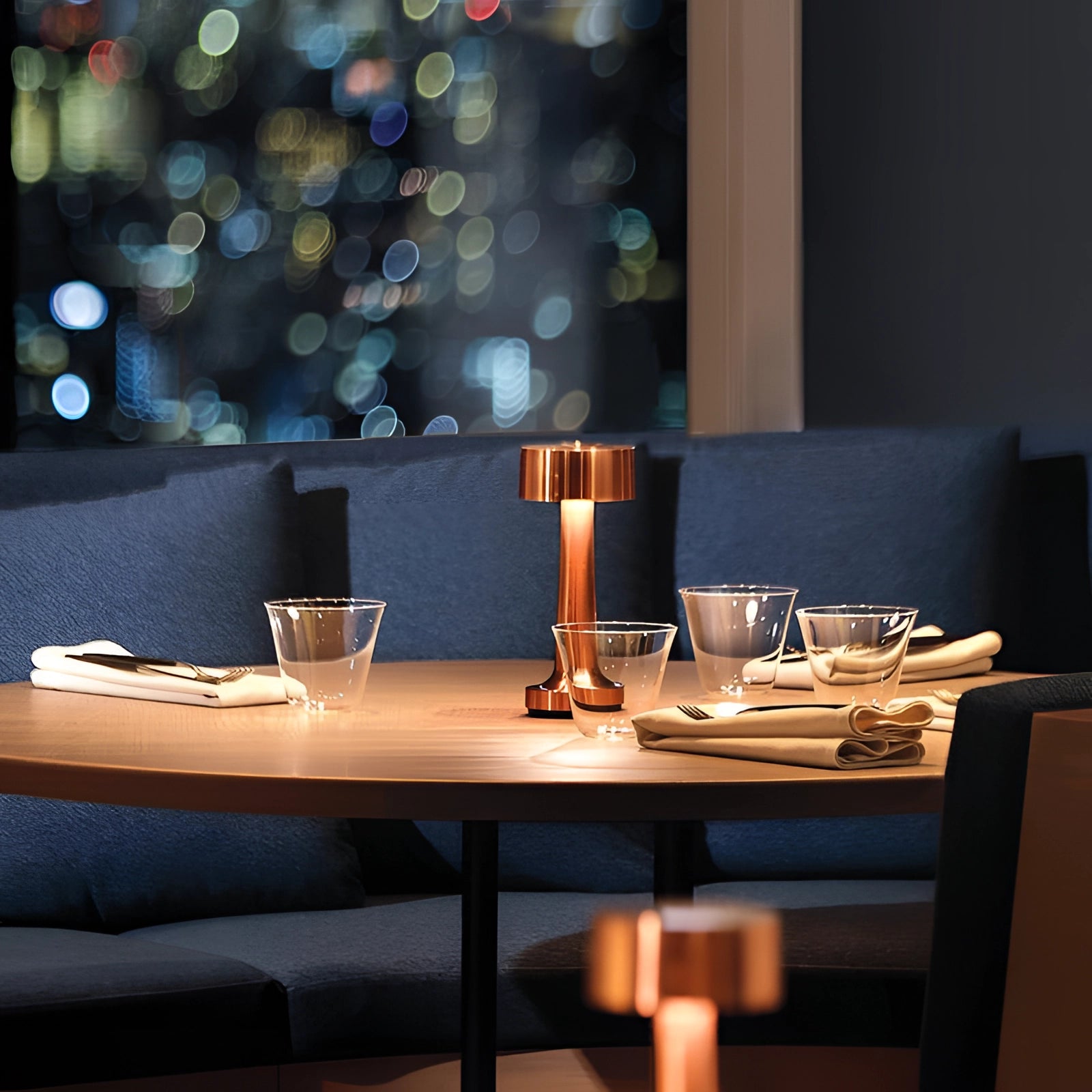 Luxury gold cordless LED table lamp on a wooden table in a stylish interior setting, surrounded by modern furnishings.