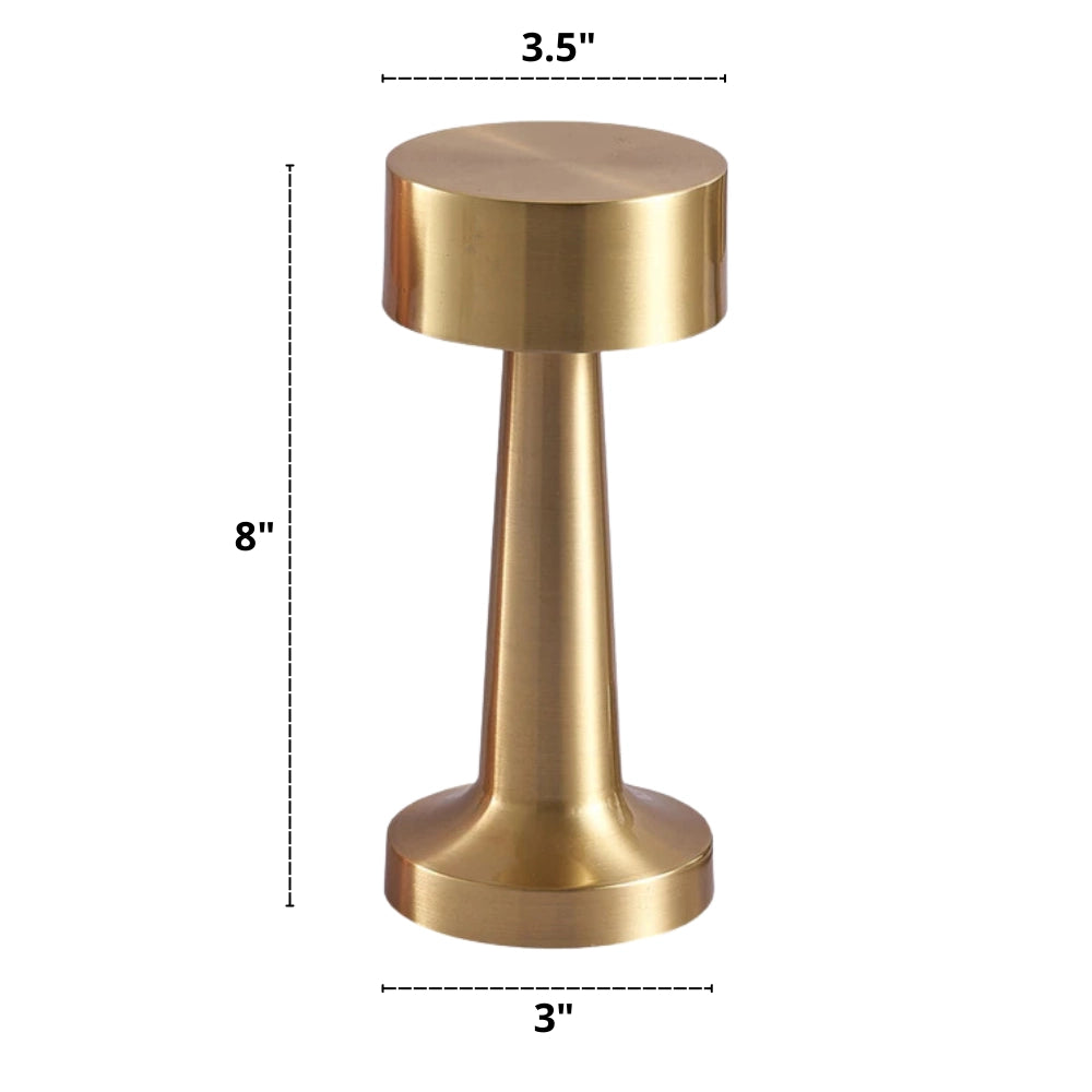 Portable luxury gold cordless LED table lamp with a sleek metal finish, placed on a wooden tabletop, showcasing its modern design and functionality as a rechargeable light fixture.