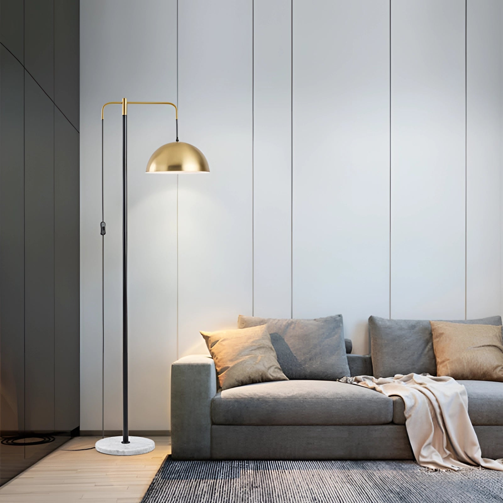 Luxury gold dome floor lamp with a modern design, featuring an adjustable arm and a marble base, situated in a stylish living room with grey flooring and contemporary furniture.