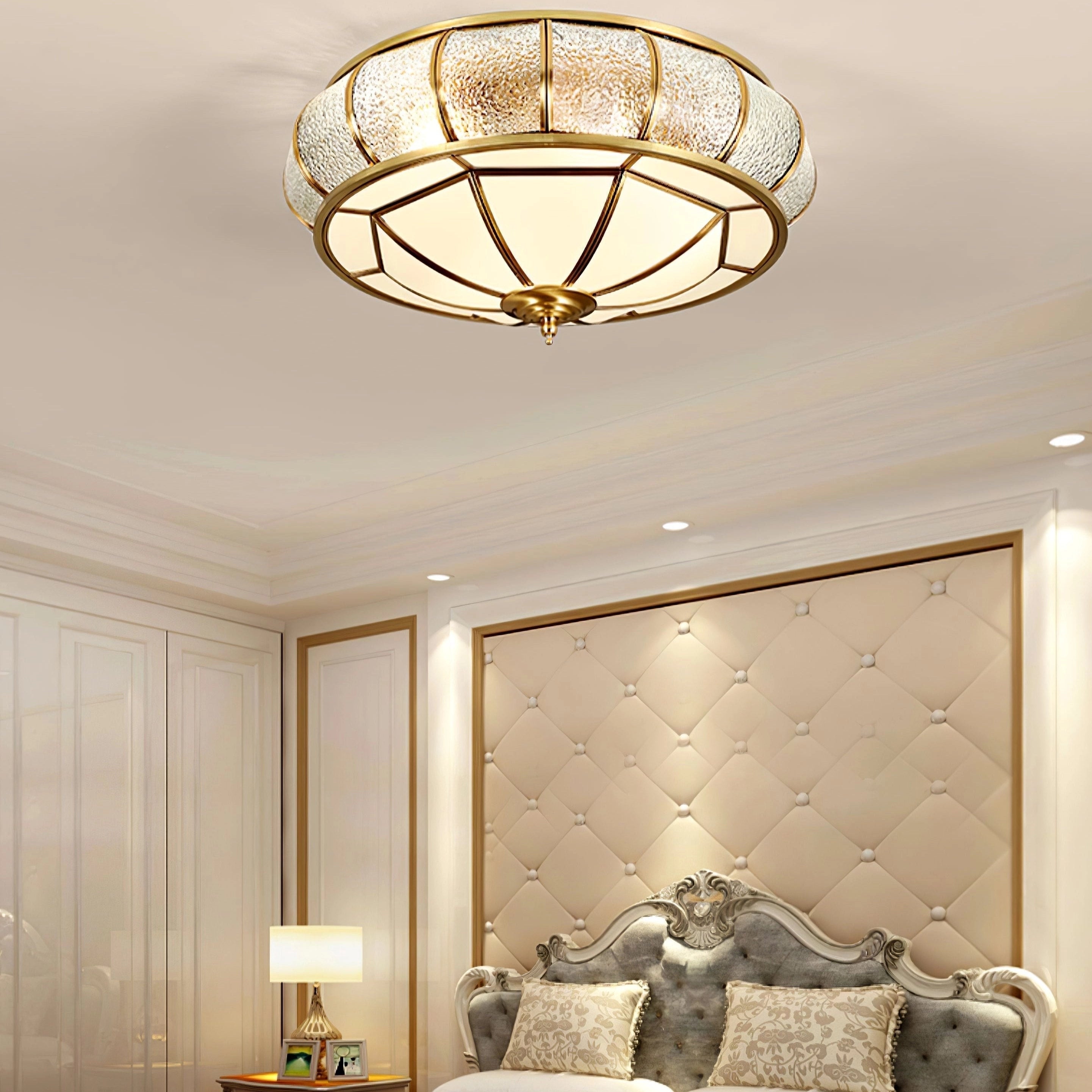 Luxury gold flush mount ceiling light with textured glass and brass accents, installed on a wooden ceiling, enhancing the interior design with warm tints and shades.