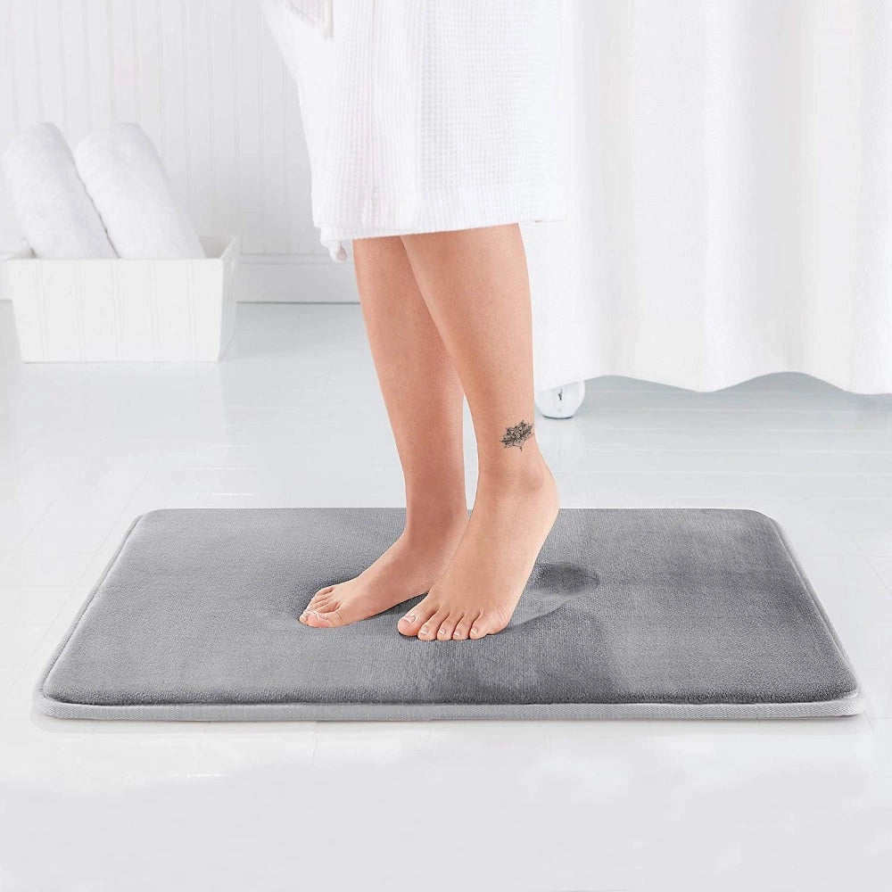 Luxury grey memory foam bath mat placed on wooden flooring, showcasing its non-slip feature. The plush material is visible, designed for comfort, ideal for barefoot use.