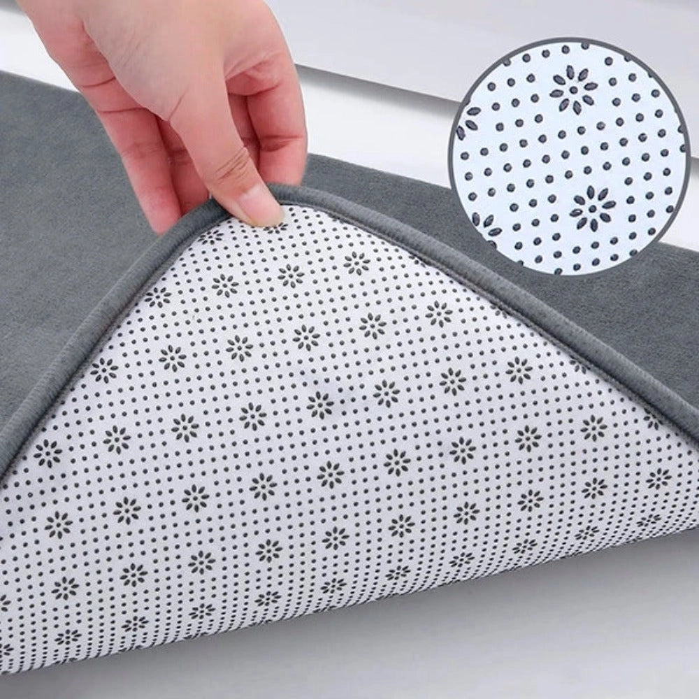 Luxurious grey memory foam bath mat with a plush texture and rectangular shape, designed to be non-slip and quick-drying, featuring a subtle pattern.