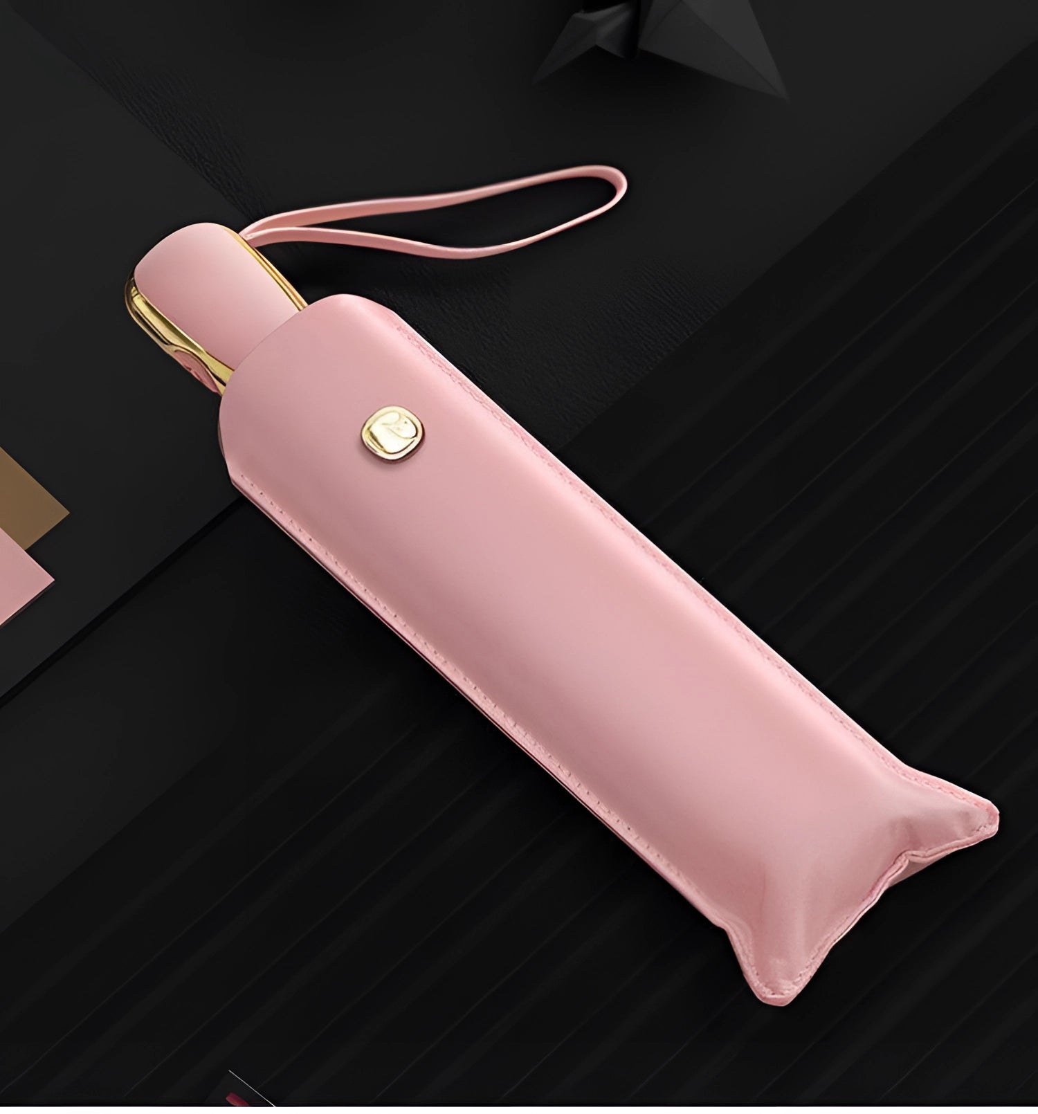 Luxury pink leather compact designer umbrella featuring a sleek pink sleeve, stylish metal accents, and a fashionable design, ideal for women's fashion accessories.