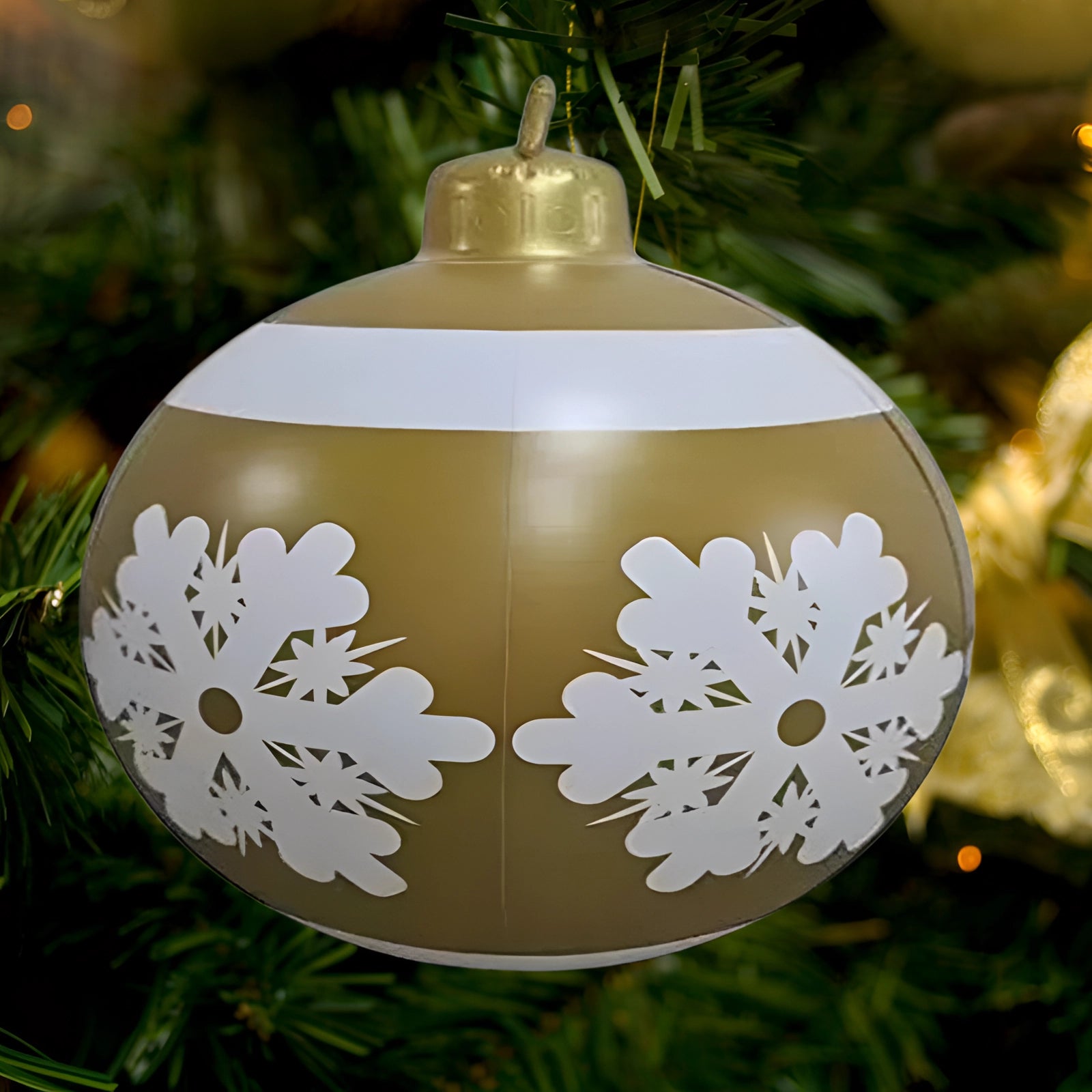 Luxury red plaid tartan glass Christmas ornament hanging from an evergreen branch, with a decorative metal lantern and soft light in the background.