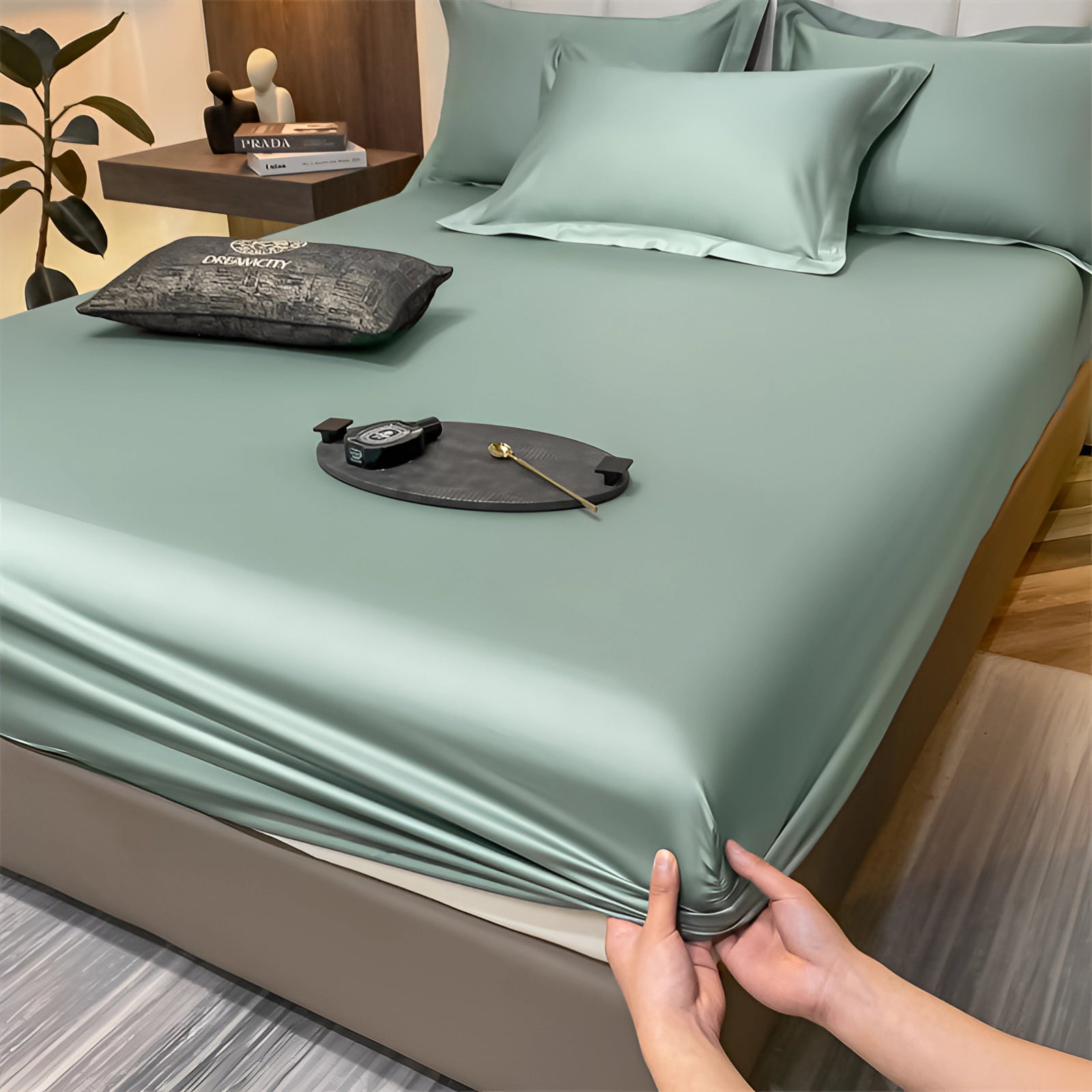 Luxurious green silk satin bedsheet set on a neatly made bed, highlighting the smooth, wrinkle-free fabric and deep pocket design.