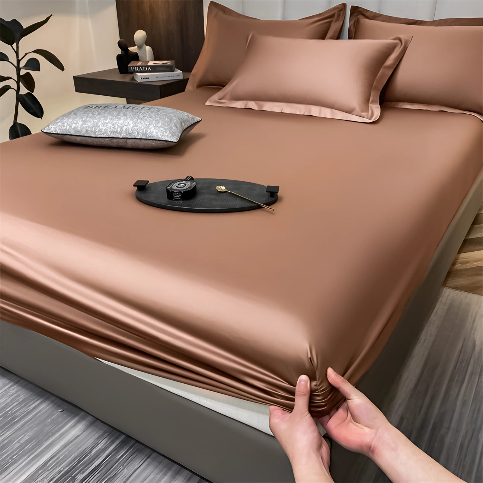 Luxurious brown silk satin bedsheet set with a wrinkle-free finish, fitted for deep pockets, displayed on a hardwood floor.