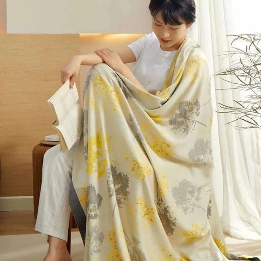Luxury silk floral throw blanket in a vibrant yellow hue, showcasing intricate fashion design elements for an elegant home decor setting.